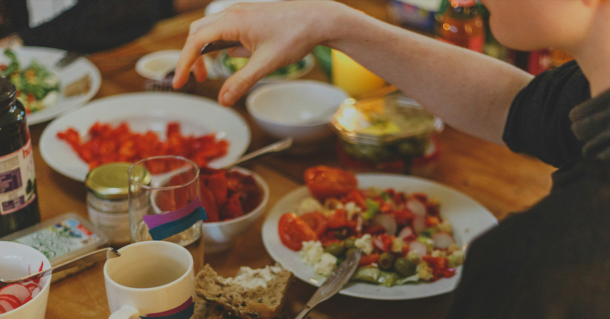 Persona comiendo alimentos variados en una comida cotidiana relacionada con la disfagia